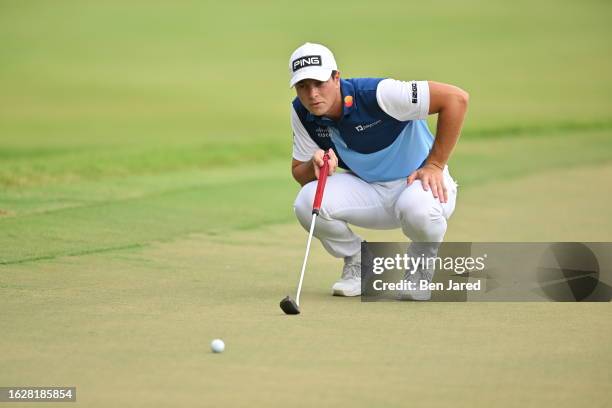 Viktor Hovland of Norway lines up a putt on the 12th green during the final round of the TOUR Championship at East Lake Golf Club on August 27, 2023...