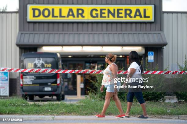 People walk past the Dollar General store where three people were shot and killed the day before on August 27, 2023 in Jacksonville, Florida. Police...