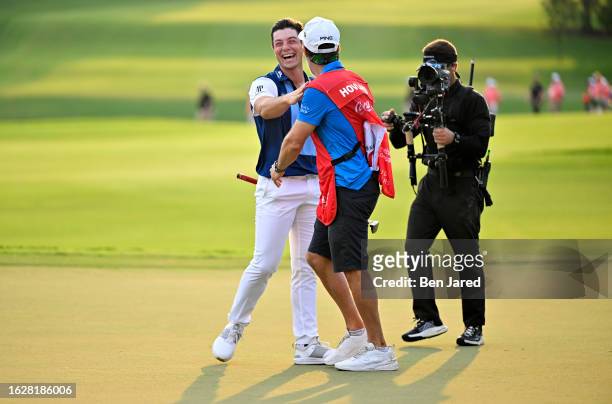 Viktor Hovland of Norway reacts to his winning putt on the 18th green with his caddie Shay Knight during the final round of the TOUR Championship at...