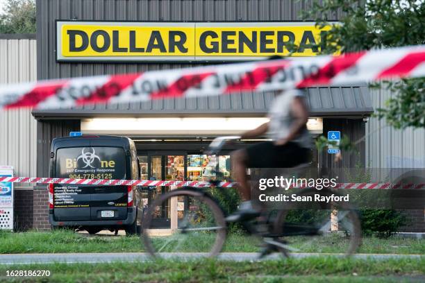 Bicyclist rides past the Dollar General store where three people were shot and killed the day before on August 27, 2023 in Jacksonville, Florida....