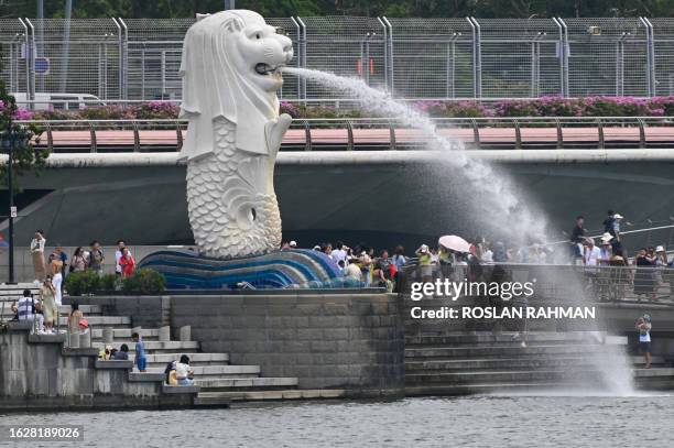 People gather around the Merlion statue at Marina Bay in Singapore on August 28, 2023.