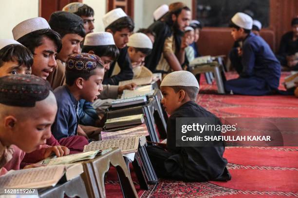 Afghan children read from the holy Quran at a madrassa or an Islamic school in Behsud district of Nangarhar Province on August 28, 2023.