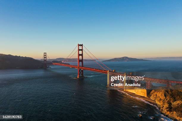 An aerial view of Golden Gate Bridge during sunset from Baker Beach in San Francisco California, United States on August 27, 2023.