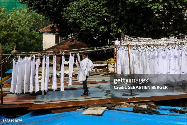 In this picture taken on August 26 a worker collects clothes those were put out for drying at an open-air laundromat, locally called 'Dhobi Ghat' in...