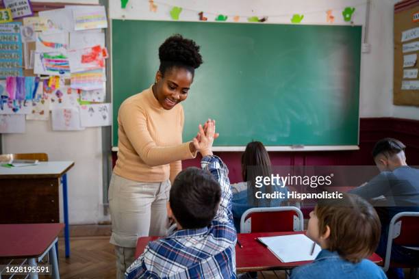 l'allegra insegnante nera che festeggiava il suo studente rispose correttamente dandogli il cinque - schoolboy foto e immagini stock