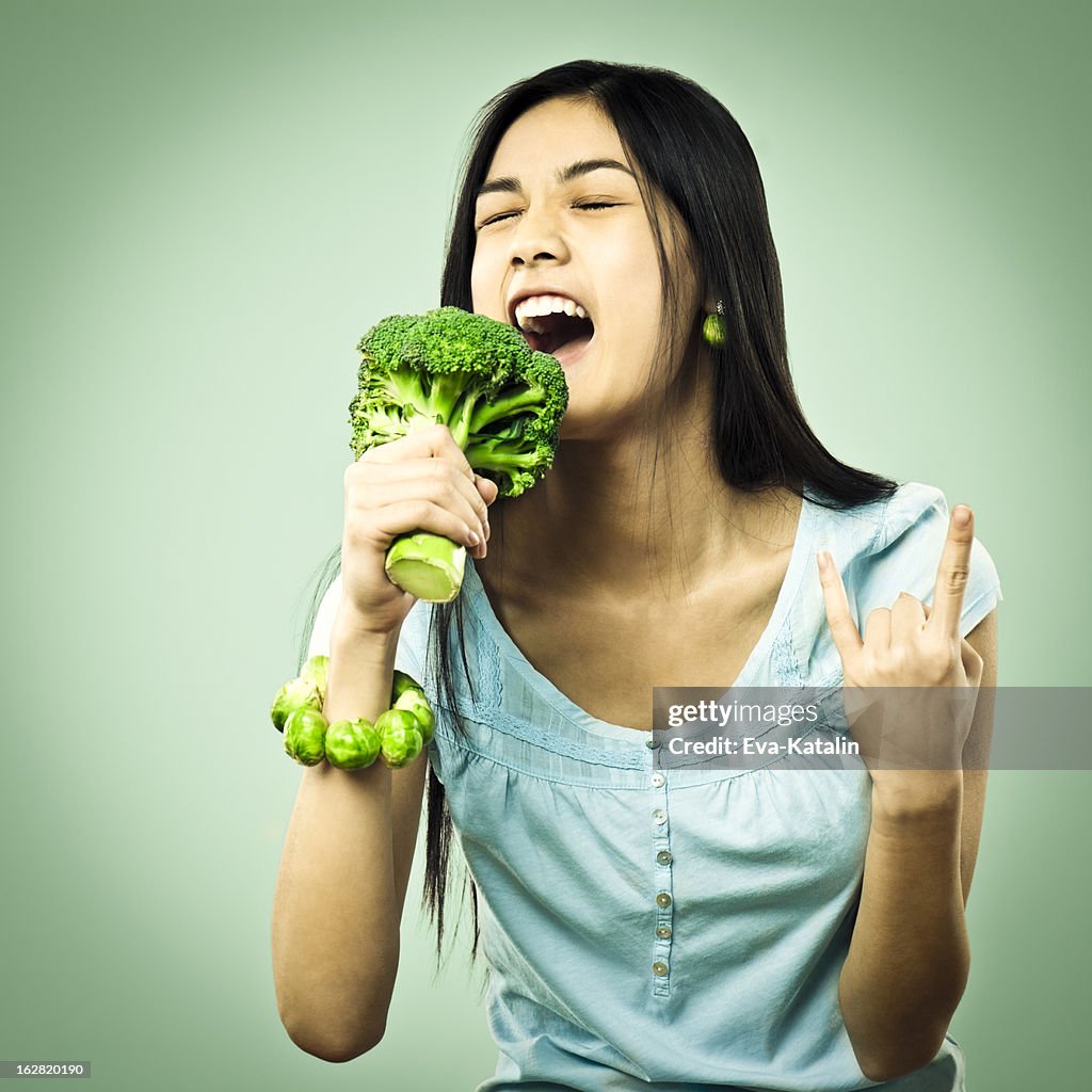 Girl singing in a broccoli microphone