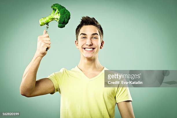 junge mit brokkoli - vegetarisch stock-fotos und bilder