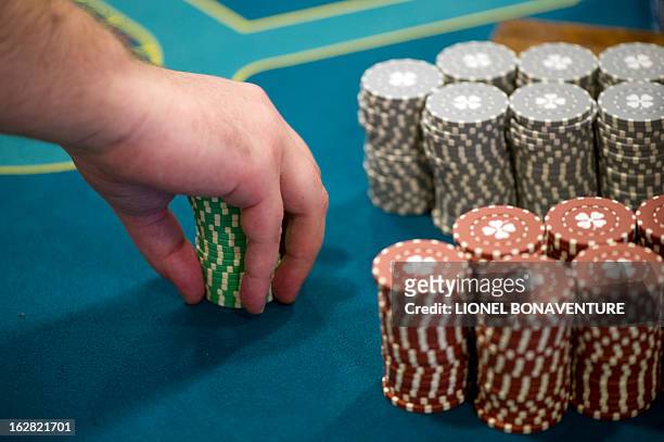 Student of the Cerus Casino Academy, a school for croupiers, deals out tokens on a black jack table in Paris, on February 27, 2013. AFP PHOTO /...