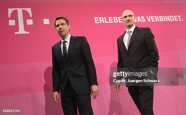 Deutsche Telekom AG chief executive officer Rene Obermann and chief financial officer Timotheus Hoettges pose on the podium at the company's annual...