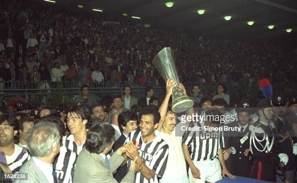 Sergei Aleinikou of Juventus holds aloft the trophy after their victory in the UEFA Cup Final second leg match against Florentina in Avellino, Italy....