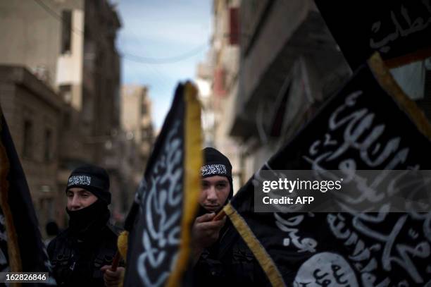 Members of Liwa Hamzah, a newly formed Islamist brigade from the Syrian eastern city of Deir Ezzor, hold flags of Jebhat al-Nusra as they take part...