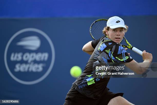Alex Michelsen of the United States returns a shot against Juan Pablo Varillas of Peru in the first round of the Winston-Salem Open at Wake Forest...