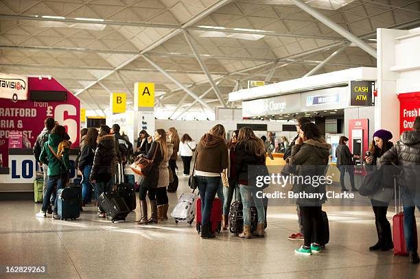 Travellers queue in the departures hall at Stansted Airport on February 28, 2013 in Bishop's Stortford, England. The deal between Heathrow Airport...