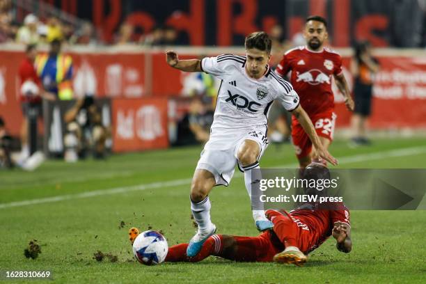 United midfielder Gabriel Pirani fights for the ball against New York Red Bulls Andres Reyes at Red Bull Arena on August 20, 2023 in Harrison, New...