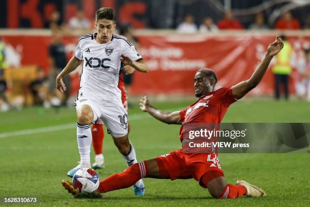 United midfielder Gabriel Pirani fights for the ball against New York Red Bulls Andres Reyes at Red Bull Arena on August 20, 2023 in Harrison, New...