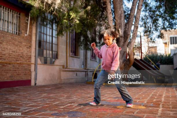 black happy girl jumping at the school playground having a great time - snakes and ladders stock pictures, royalty-free photos & images