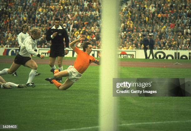 Holland player Johan Cruyff is tripped by Uli Hoeness of Germany for a penalty kick in the 1st minute of the game watched by referee Jack Taylor...