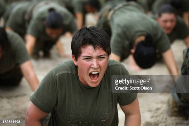 Female Marine recruits are disciplined with some unscheduled physical training in the sand pit outside their barracks during boot camp February 27,...