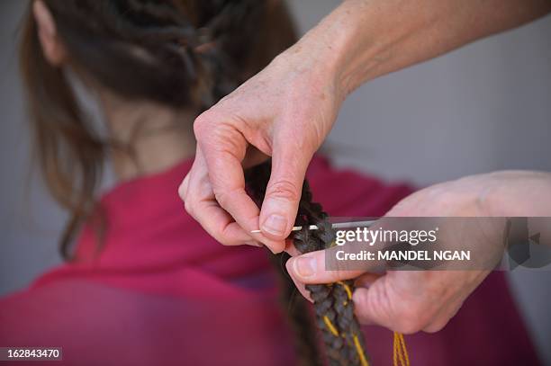 Hairdress Janet Stephens works on the hair of model Jackie Rose Womelsdorf to recreate the hairstyle worn by Roman Empress Faustina on February 25,...