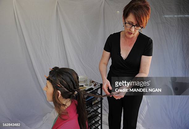 Hairdress Janet Stephens works on the hair of model Jackie Rose Womelsdorf to recreate the hairstyle worn by Roman Empress Faustina on February 25,...
