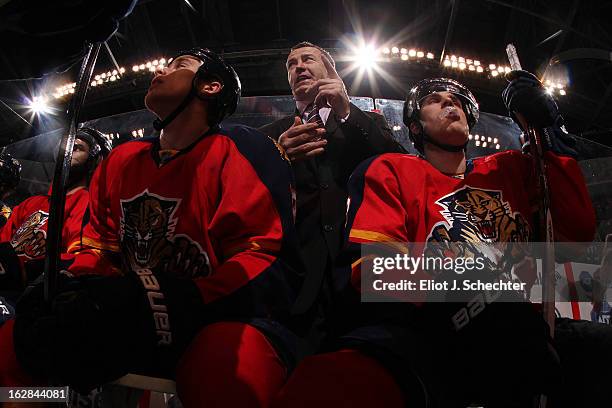 Head Coach Kevin Dineen of the Florida Panthers directs his team from the bench with players Shawn Matthias and Mike Santorelli between shifts...