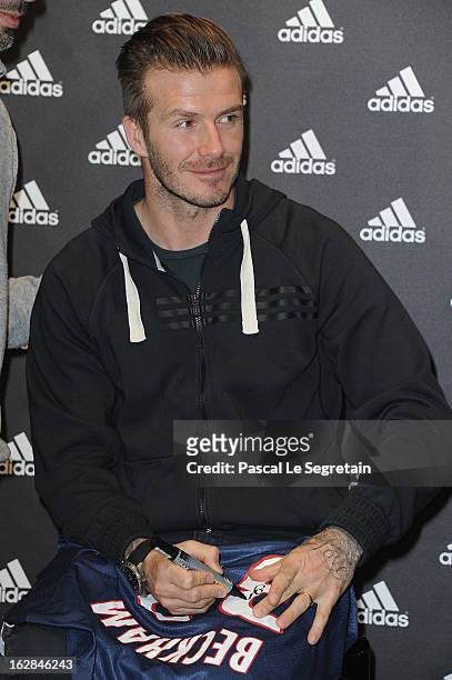 David Beckham signs his new Paris Saint-Germain jersey as he attends an autograph session at adidas Performance Store Champs-Elysees on February 28,...