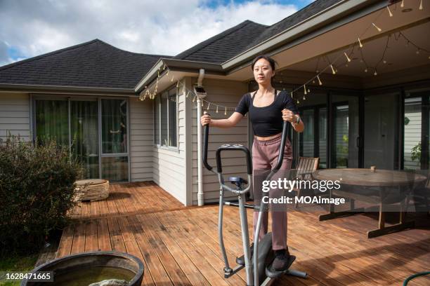 a young girl using elliptical machine - cross trainer stock-fotos und bilder