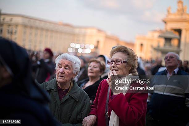 Woman follows the livestreaming online coverage of Pope Benedict XVI's arrival in Castel Gandolfo on a screen in St Peter's Square on February 28,...