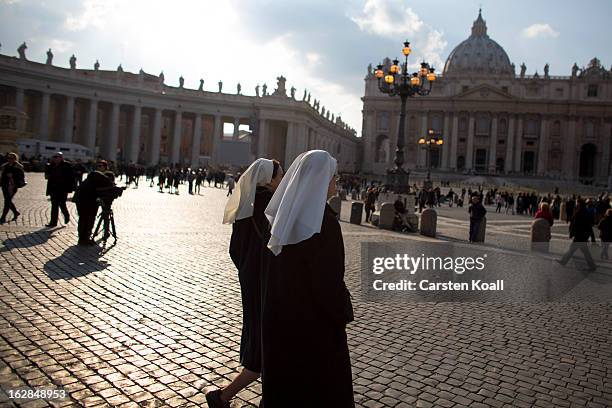 Two nun walks to follow the livestreaming online coverage of Pope Benedict XVI's depature to Castel Gandolfo on a screen in St Peter's Square on...
