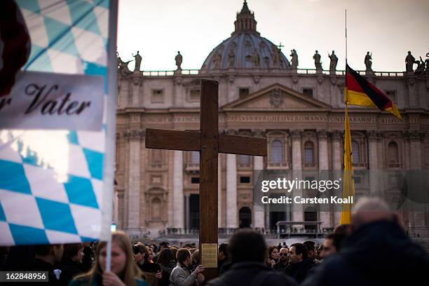 Cruzifix is held by people in front of St. Peter's Basilica on February 28, 2013 in Vatican City, Italy. Pope Benedict XVI has been the leader of the...