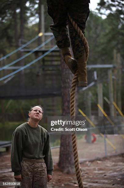 Marine recruit Brany Rogers of Woodland, Washington watches as another recruit navigates an obstacle on the Confidence Course during boot camp...