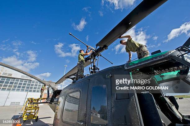 Members of the Uruguayan Air Force Brigade 1 repair a helicopter at the Air Base in Canelones, near Montevideo, on February 27, 2013. AFP PHOTO/Mario...