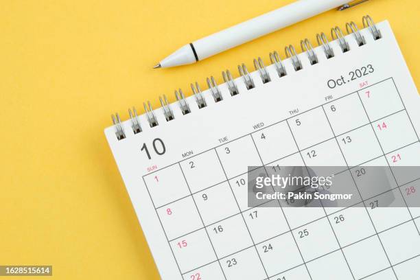 calendar desk 2023: october is the month for the organizer to plan and deadline with a white pen on a yellow paper background. - oktober stock pictures, royalty-free photos & images