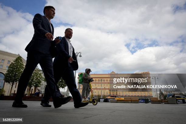 Men walk in front of the headquarters of Russia's Federal Security Services in central Moscow on August 28, 2023. Russia on August 28, 2023 accused a...