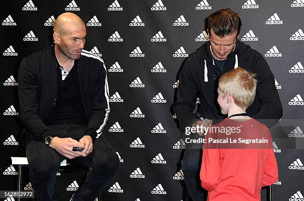 Zinedine Zidane and David Beckham meet with a fan as they attend an autograph session at adidas Performance Store Champs-Elysees on February 28, 2013...