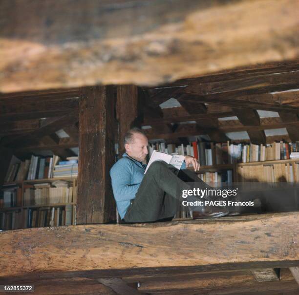 Haroun Tazieff At Home In Paris. Paris, novembre 1964. Le volcanologue Haroun TAZIEFF lit un livre, installé dans la charpente de la mezzanine de son...