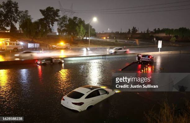 Cars are seen submerged in floodwaters on the Golden State Freeway as tropical storm Hilary moves through the area on August 20, 2023 in Sun Valley,...