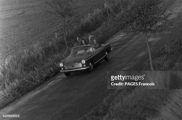 Presentation Of The Peugeot 404. France, 28 septembre 1961, Présentation en extérieur d'une voiture Peugeot 404 cabriolet par deux mannequins femmes...