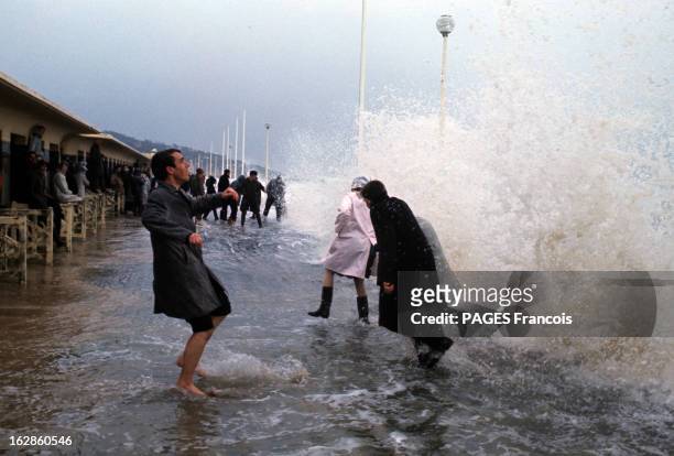Tide Of The Century In Deauville. En France, à Deauville, le 27 mars 1967, lors d'une grosse marée, les habitants, portant des imperméables, sur la...