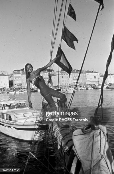 Its Parties, Its Beaches. France, Saint-Tropez, août 1967 : jeune mannequin souriant, se tenant debout à l'avant d'un voilier.