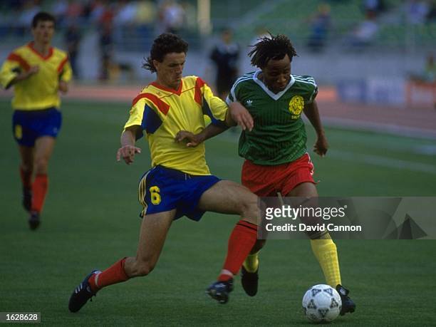 Gheorghe Popescu of Romania tackles Cyrille Makanaky of Cameroon during the World Cup match at the Sant Nicola Stadium in Bari, Italy. Cameroon won...