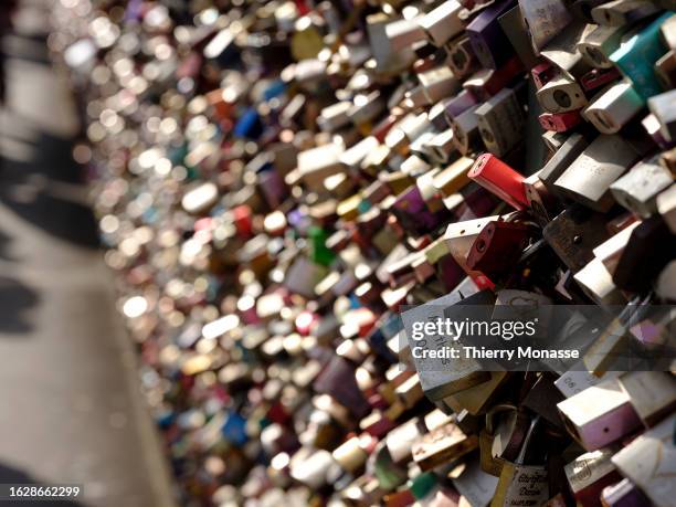 Love Locks are attached to the fence of the Hohenzollern Bridge over the Rhine river on August 26, 2023 in Cologne, Germany. Love locks are a modern...