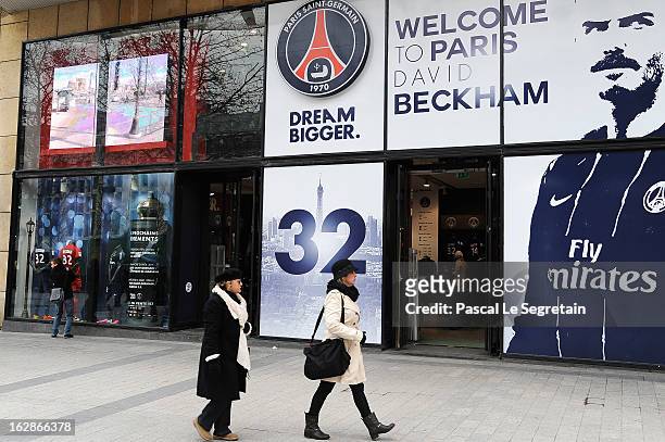 Pedestrians walk past the Paris Saint Germain football club's official shop displaying a portrait of David Beckham, opposite the adidas Performance...