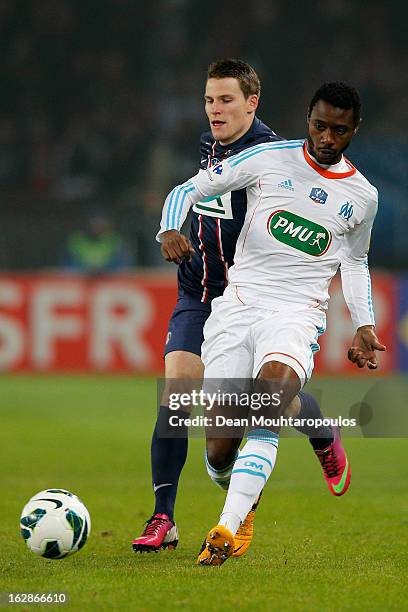 Kevin Gameiro of PSG is beaten to the ball from Nicolas N'Koulou of Marseille during the French Cup match between Paris Saint-Germain FC and...