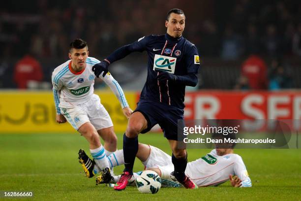 Zlatan Ibrahimovic of PSG beats Michel Lucas Mendes and Joey Barton of Marseille during the French Cup match between Paris Saint-Germain FC and...