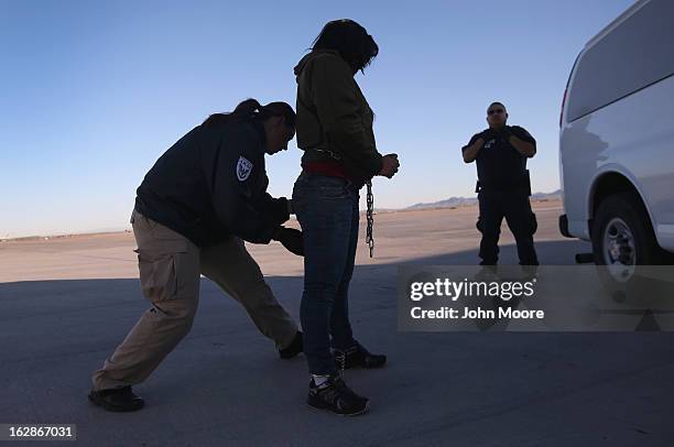 Security contractor frisks a female immigration detainee from Honduras ahead of a deportation flight to San Pedro Sula, Honduras on February 28, 2013...