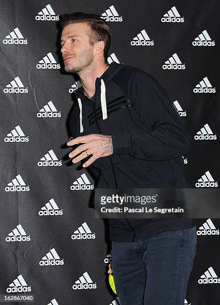 David Beckham throws a ball towards fans as he attends an autograph session at adidas Performance Store Champs-Elysees on February 28, 2013 in Paris,...