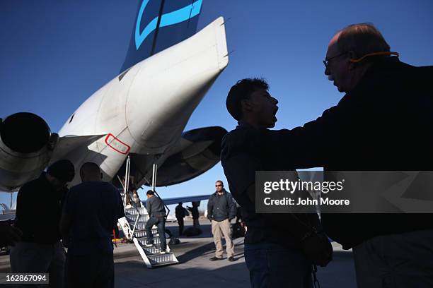 Security contractor hired by U.S. Immigration and Customs Enforcement , checks the mouth of a Honduran immigration detainee from Honduras before a...