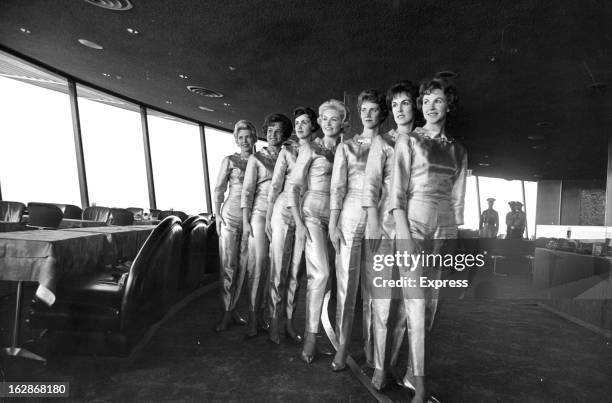 Gold-Lame suited waitresses inside Seattle Space Needle's restaurant at Seattle's World's Fair, 4/25/62.