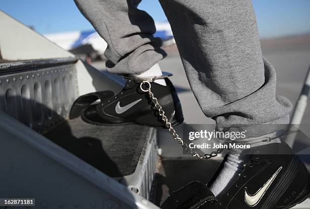 Honduran immigration detainee, his feet shackled and shoes laceless as a security precaution, boards a deportation flight to San Pedro Sula, Honduras...